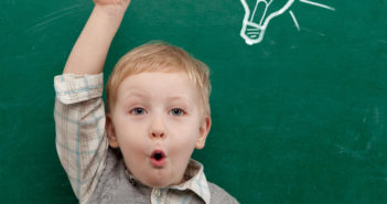 Cheerful smiling child at the blackboard.