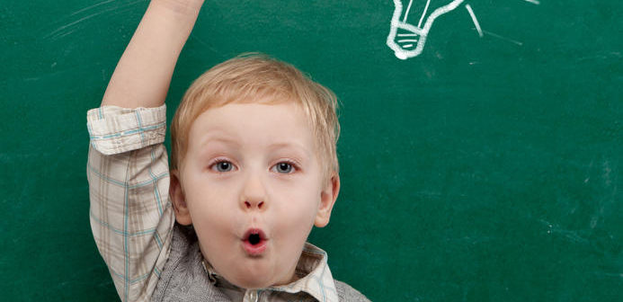 Cheerful smiling child at the blackboard.